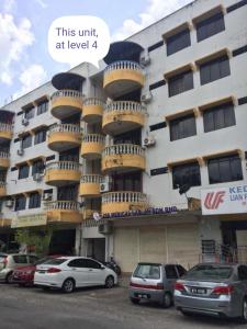 马六甲DT Homestay floor level 4的前面有汽车停放的建筑