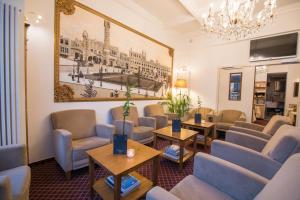 根特罗德酒店的一间设有桌椅的等候室和墙上的绘画