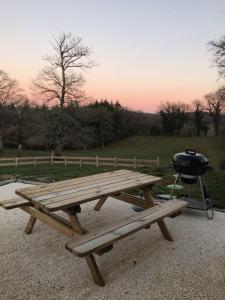 AugèresGîte de charme Les Trois Chênes的野餐旁带烧烤架的野餐桌