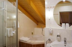 施万高谷咕霍夫乡村酒店的带浴缸、水槽和镜子的浴室