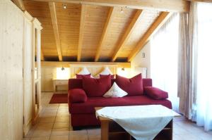 施万高谷咕霍夫乡村酒店的客厅配有红色的沙发和桌子