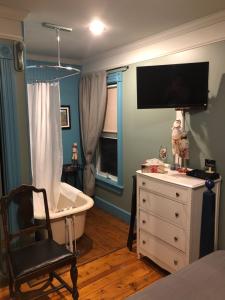 Petit RocherAuberge d'Anjou-Cocooning Café的一间带浴缸、椅子和电视的卧室