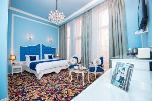 第比利斯River Side Hotel Tbilisi的蓝色的卧室设有床和大窗户