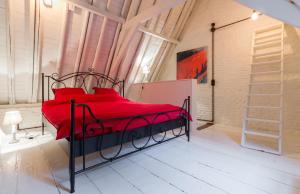根特Romantic 16th century workers house的一间卧室配有红色的床和红色枕头