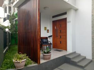 万隆Homestay Syariah Cileunyi, Bandung Timur的木门房子的入口