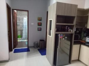 万隆Homestay Syariah Cileunyi, Bandung Timur的带冰箱的厨房和通往客房的门