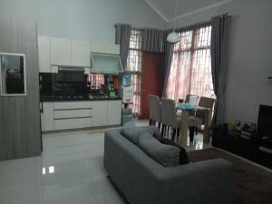 万隆Homestay Syariah Cileunyi, Bandung Timur的带沙发和桌子的客厅以及厨房。