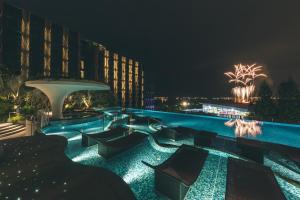 新加坡Village Hotel Sentosa by Far East Hospitality的夜间带游泳池的度假村