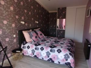 蒙莫里永19 Rue du Cadran的一间卧室配有一张带花卉壁纸的床