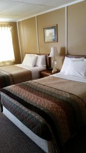 VirginiaLakeshor Motor Inn的酒店客房设有两张床和窗户。