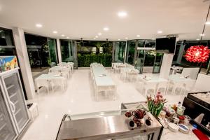 拉廊Baan Yamoo Ranong的用餐室配有白色的桌子和白色的椅子