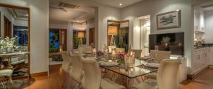 莱利海滩Villa Macaque and Villa Languor的一间设有玻璃桌和白色椅子的用餐室