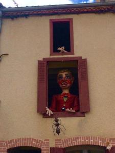 GourgéBois Mort farm的一只小丑脸从窗户上粘下来的男孩雕像