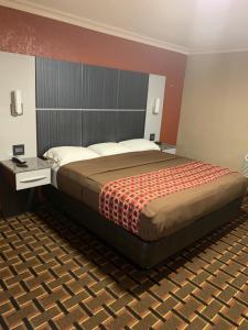 莱克威尔士威尔士湖经济旅馆的一间卧室,卧室内配有一张大床