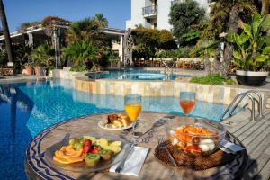 萨沃纳梅尔酒店的游泳池旁的餐桌,供应食物和饮料