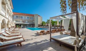 拉加纳斯Natalie Hotel的酒店庭院设有躺椅和游泳池