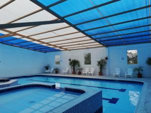 安巴托Quinta Spa El Rosal的一座拥有蓝色天花板的大型游泳池