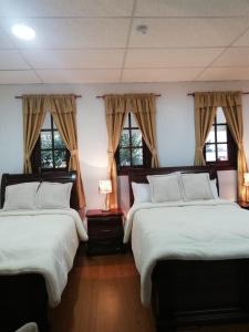 安巴托Quinta Spa El Rosal的带2扇窗户的客房内的2张床