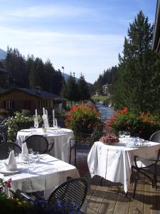 圣卡特琳娜瓦尔夫罗曼蒂克酒店的庭院里设有两张带白色桌布的桌子