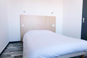 里摩日里莫日迎宾汽车旅馆的卧室配有白色的床和木制床头板