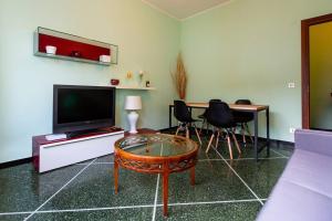 迪亚诺马里纳Luxury Guest House - Diano Marina的客厅配有电视和桌椅