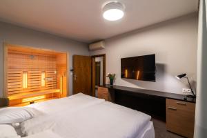 胡门内卡尔帕提亚酒店的一间卧室配有一张床和一台平面电视
