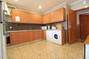 斯代塔维拉Casa da Amoreira的厨房配有木制橱柜、洗衣机和烘干机