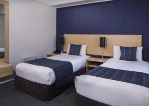 惠灵顿威利斯惠灵顿酒店的酒店客房,设有两张带蓝色墙壁的床