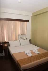 杜马格特最佳酒店的一间卧室配有带毛巾的床