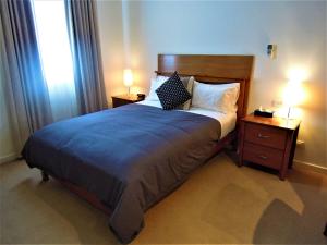 墨尔本Plough Hotel的一间卧室配有一张带2个床头柜和2盏灯的床。