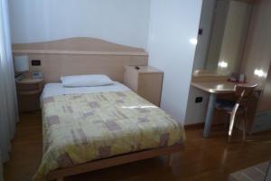 阿维奥小花酒店的一间小卧室,配有一张床和一张书桌