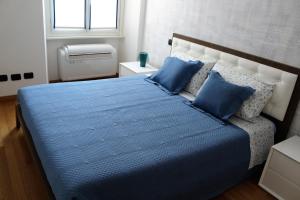 科莫Perfect apartment Como的一间卧室配有一张带蓝色床单的床和一扇窗户。