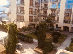 克拉科夫Family Apartments - Private Parking的庭院里树木繁茂的公寓楼