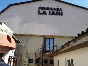 康斯坦察Pensiunea La Iani的白色的建筑,旁边标有标志