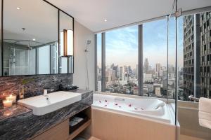 曼谷Sivatel Bangkok Hotel的带浴缸的浴室和大窗户