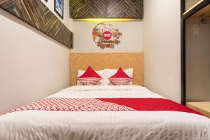 棉兰SUPER OYO 456 Aljadid Guest House Syariah的卧室配有带红色枕头的白色床
