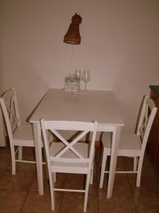凯尔德拉Vabaduse Apartment的白色的桌椅、灯和酒杯