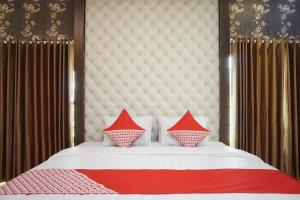 日惹Super OYO 444 Rafitha Homestay的一张带红色和白色枕头的床