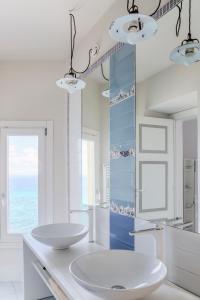 特罗佩阿Palazzo Mottola Tropea的白色的浴室设有两个盥洗盆和镜子