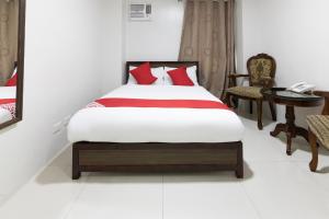 马尼拉OYO 152 Sangco Condotel的一间卧室配有一张床、一部电话和一张桌子