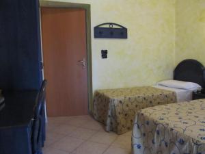 安齐奥阿普罗多酒店的一间设有两张床和一扇门的房间