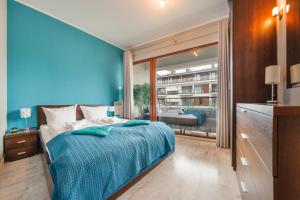 斯维诺乌伊希切Apartamenty Sun & Snow Plaża I的蓝色的卧室设有床和大窗户