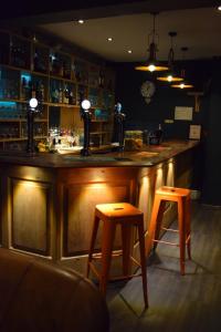 卡纳芬Ty Glyndwr Bunkhouse, Bar and cafe的一间酒吧,在房间里有两个凳子