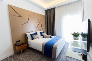 萨拉热窝奥斯特波斯纳伊利扎酒店的酒店客房设有一张大床和一张书桌。
