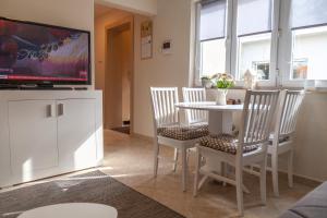 诺维萨德DC Executive Homes的客厅配有桌椅和电视。