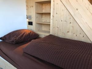 迪森蒂斯Catrina Hostel的卧室内的一张床铺,设有木墙