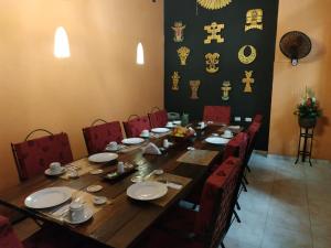 卡塔赫纳卡萨印度卡特琳娜酒店的一张带红色椅子的木桌和一张带盘子的长桌