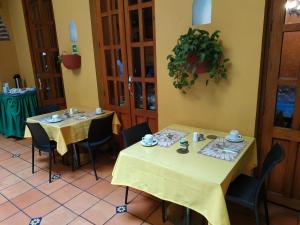 卡塔赫纳卡萨印度卡特琳娜酒店的餐厅设有两张桌子,配有黄色桌布