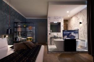 亨克Hotel Zuid的一间带浴缸的浴室和一台电视。