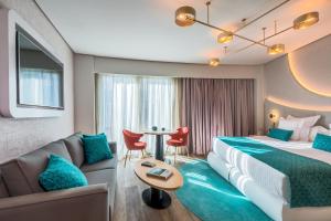 塞维利亚巴塞罗塞维利亚雷纳西门图酒店的酒店客房设有两张床、一张沙发和一张桌子。